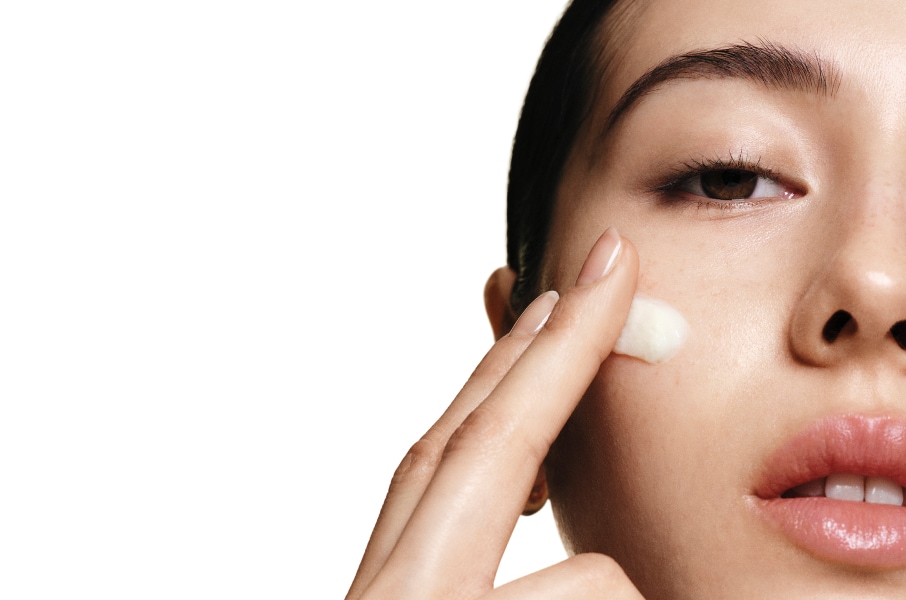 Model applying Skin Long-Wear Weightless Foundation to skin with a foundation brush